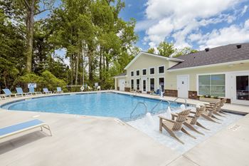 A pool with a blue bench and a building in the background